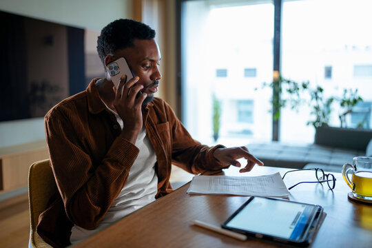 Man on phone reviewing docs
