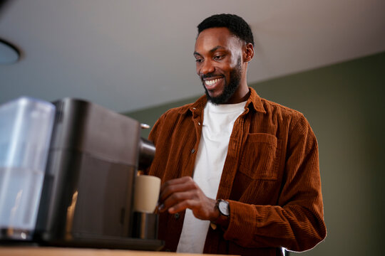 Man prepares coffee in kitchen at home
