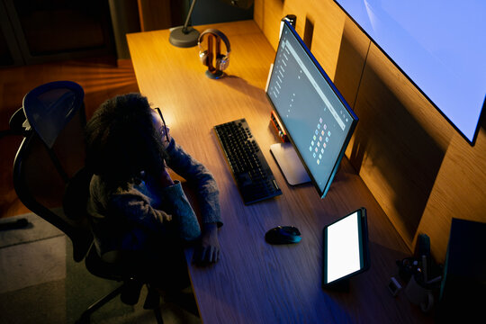 Person using computer at desk in evening
