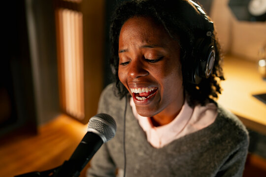 Woman sings at a recording studio
