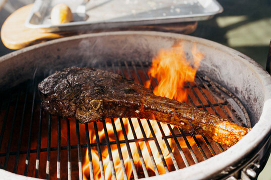 Cooking a Tomahawk steak on an outdoor grill