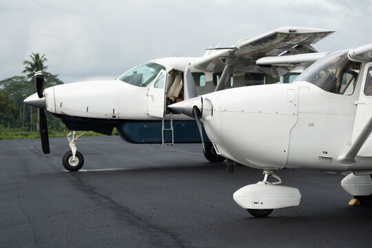 Two single engine general aviation aircraft parked on airport apron
