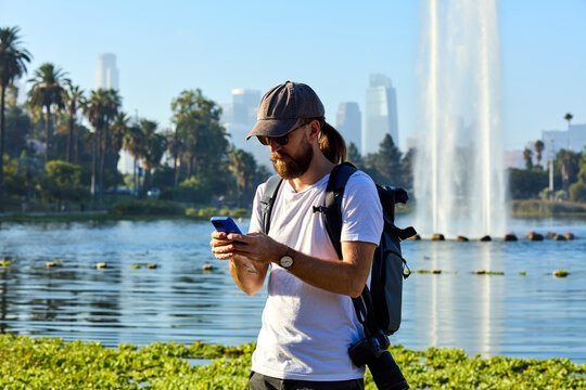 Man uses his phone by the Echo Park lake in LA