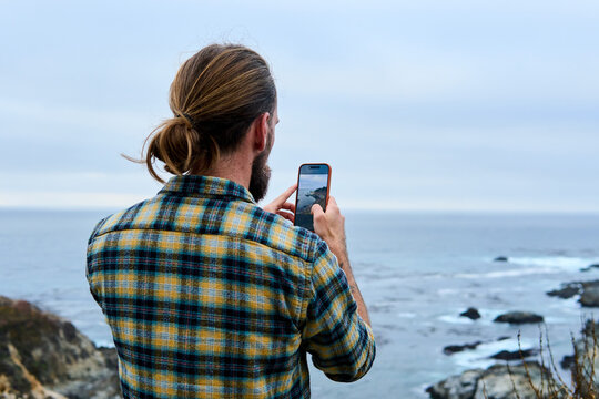 Man takes pictures on the Pacific coast of California
