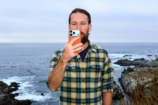 Man takes selfies on the Pacific coast with his phone