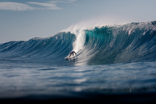 Surfer navigating a giant barreling wave off the coast of Lanzarote