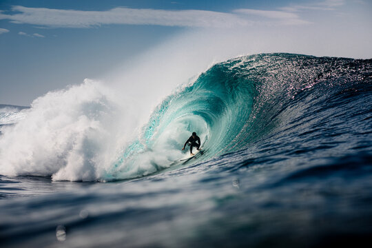 Ocean view shows a professional surfer inside a massive barreling wave