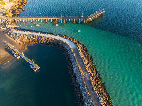 Walkway along a rock breakwater around a small harbor