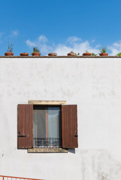 White Wall, Open Shutters, Potted Plants, Blue Sky