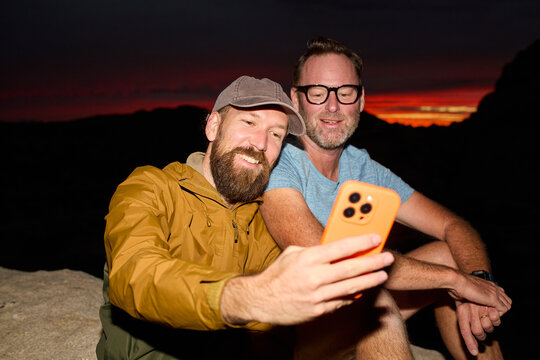 Friends taking selfies at dusk