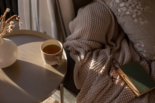 Cup of herbal tea on a sunlit table in a warm and cosy environment.