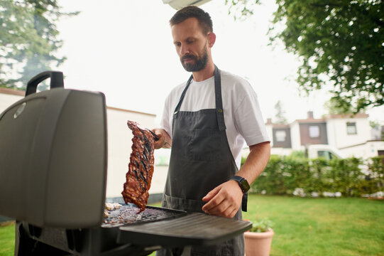Man Grilling Meat Outdoors