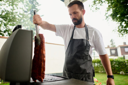 Man Grilling Meat Outdoors