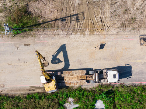 Aerial View of Excavator Unloading from Transport Truck