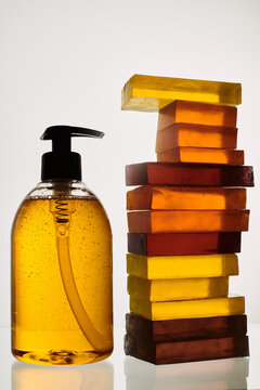 Liquid soap next to colorful stacked soaps