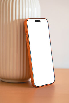 Smartphone on table in indoor setting with empty screen