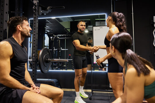 Group talks and handshakes during gym training session