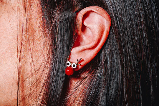 the ear of a woman with a reindeer earring