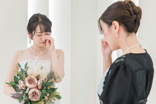 A guest, attendee, and woman in attendance, and the bride and groom, crying at a wedding