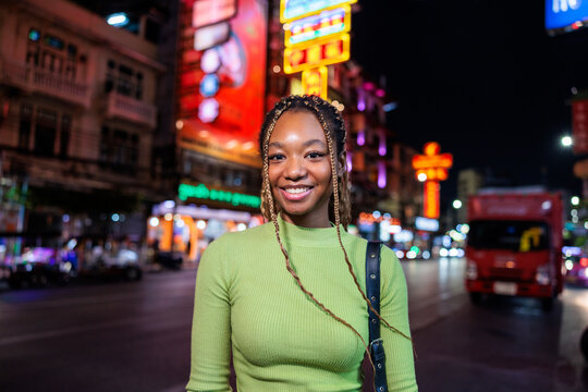 Smiling woman in Chinatown at night.