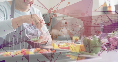 Fotobehang Koken Mixing herbs in clear bowl, woman in striped apron preparing food at kitchen counter, copy space  © vectorfusionart