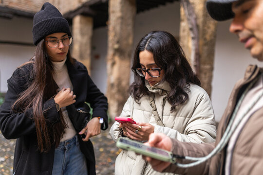Three Adults Checking Their Phones in the City