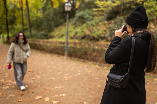 Woman photographing her partner in park