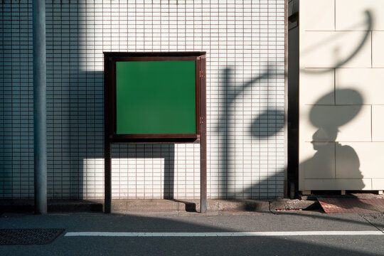 Blank green board with copy space on sidewalk