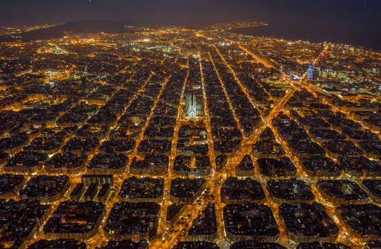 Aerial night view of Barcelona Eixample grid and Sagrada Familia illuminated, Spain