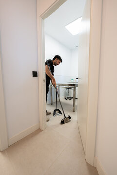 Janitor sweeping floor in veterinary hospital clinic