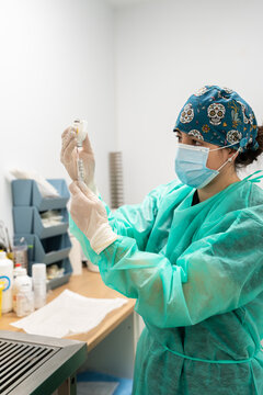 Veterinarian preparing medicine with syringe in hospital