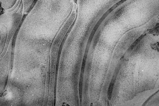 Abstract monochrome winter background with lines on frozen water