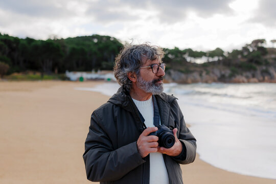 Mature man photographing nature on a scenic beach