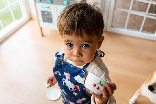 Toddler boy playing chef with toy kitchenware
