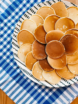 Pancakes stacked on a plate with a checkered cloth
