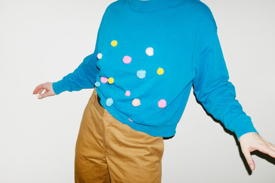 Person wearing shirt with colourful furry dots with direct flashlight