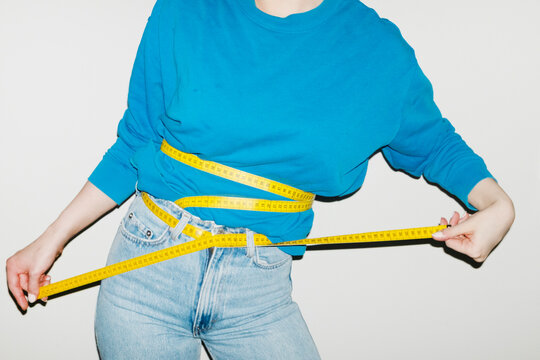 Person having yellow measurement tapes around their body with flash