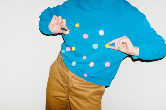 Person wearing shirt with colourful furry dots with direct flashlight