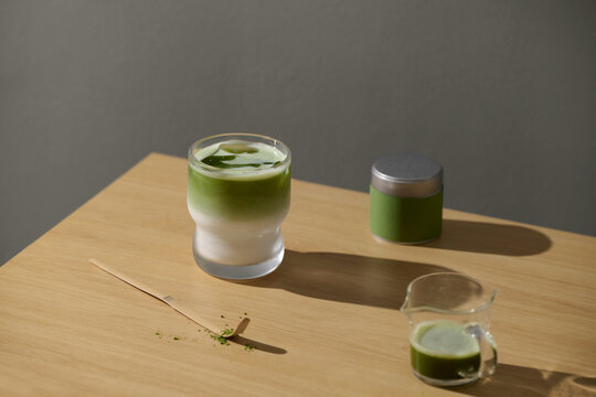 Refreshing matcha latte with ingredients on a wooden table