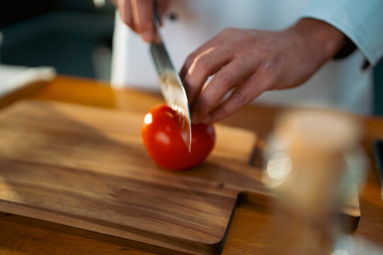 Cutting tomato with a sharp knife
