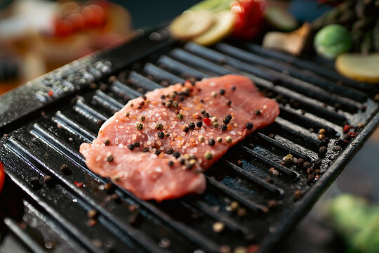 Cooking meat on a grill with spices
