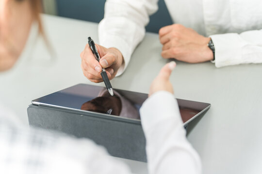 Staff using a tablet to guide customers and customers operating and signing
