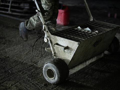 Manual concrete spreader cart on fresh concrete