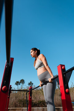 Pregnant woman exercising doing one leg squats outdoors 