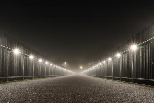 A modern foot bridge on a foggy winters night