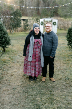 portrait of happy couple at Christmas tree farm 