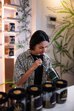 Woman examines cannabis in dispensary