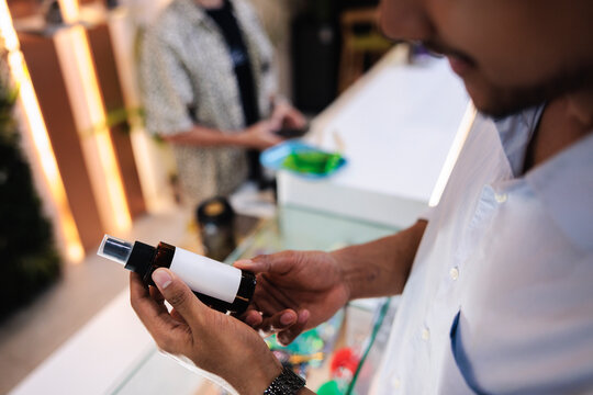 Customer examines Cannopi CBD pillow mist at store counter.