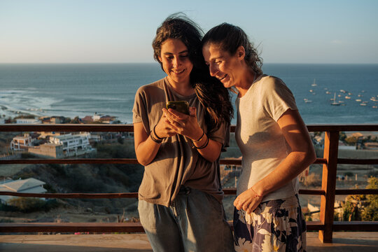 Two female friends  sharing joyful moment with phone