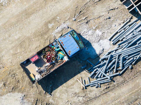 Aerial view of work truck and pipes on construction site